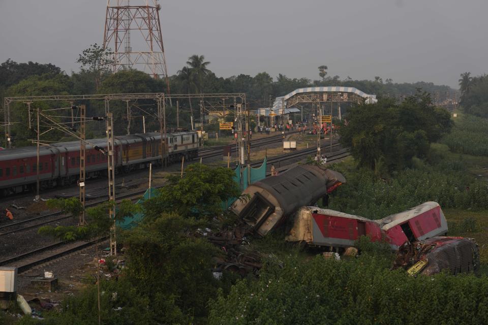 A passenger train passes by the site where two passenger trains derailed Friday in Balasore district, in the eastern Indian state of Orissa, Monday, June 5, 2023. The derailment in eastern India that killed over 200 people and injured hundreds was caused by an error in the electronic signaling system that led a train to wrongly change tracks and crash into a freight train, officials said Sunday. (AP Photo/Rafiq Maqbool)