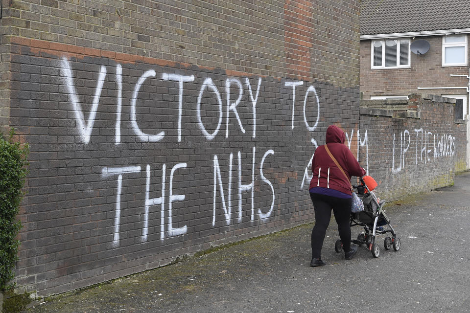 A woman walks past a message of support for the NHS in Londonderry, as the UK continues in lockdown to help curb the spread of the coronavirus. (Photo by Michael Cooper/PA Images via Getty Images)