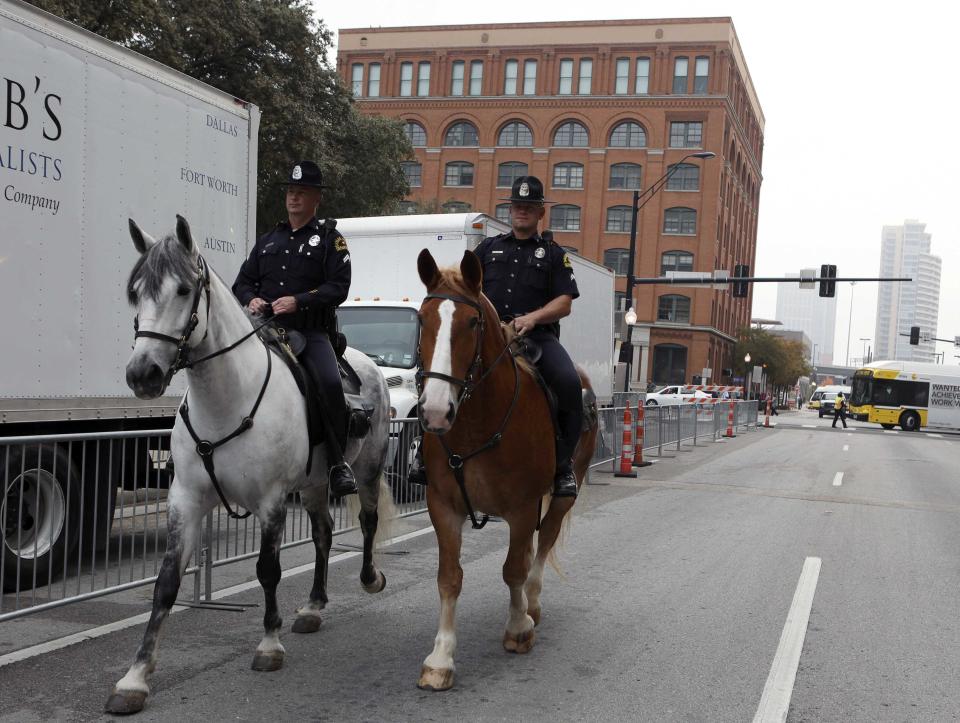 Dallas police officers on horseback patrol in front of the Texas School Book Depository where assassin Lee Harvey Oswald fired on President John F. Kennedy in 1963 as preparations continue for ceremonies commemorating the 50th anniversary of the assassinat