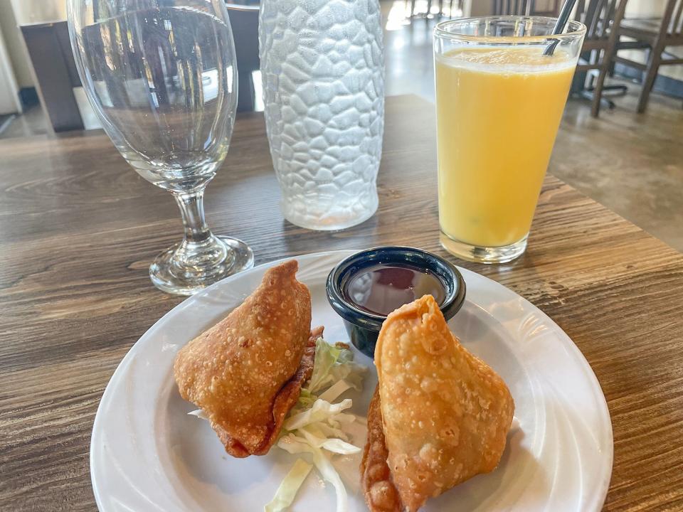 Vegetable samosa appetizers with a mango lassi drink at Taste of India restaurant in Athens, Ga. on Thursday, Oct. 19, 2023.