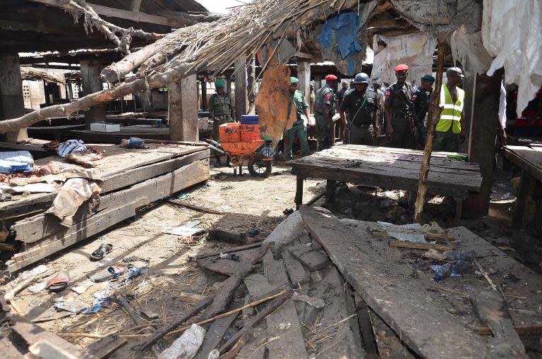 Nigerian policemen inspect the site of a suicide attack at a busy cattle market in Maiduguri on June 2, 2015