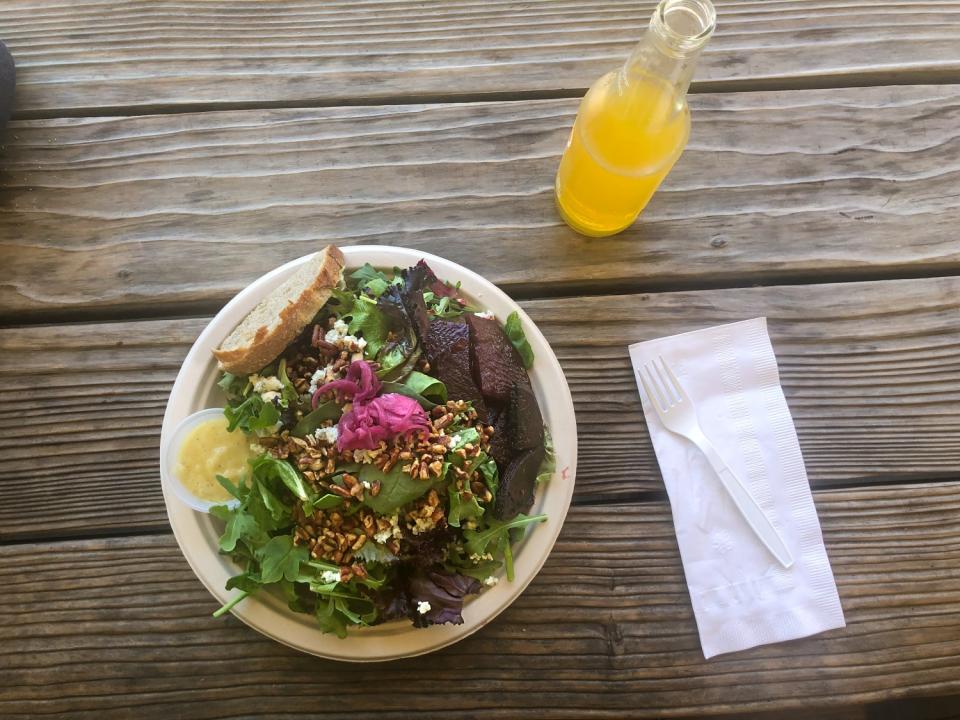 Plate of food sits on a wooden table.