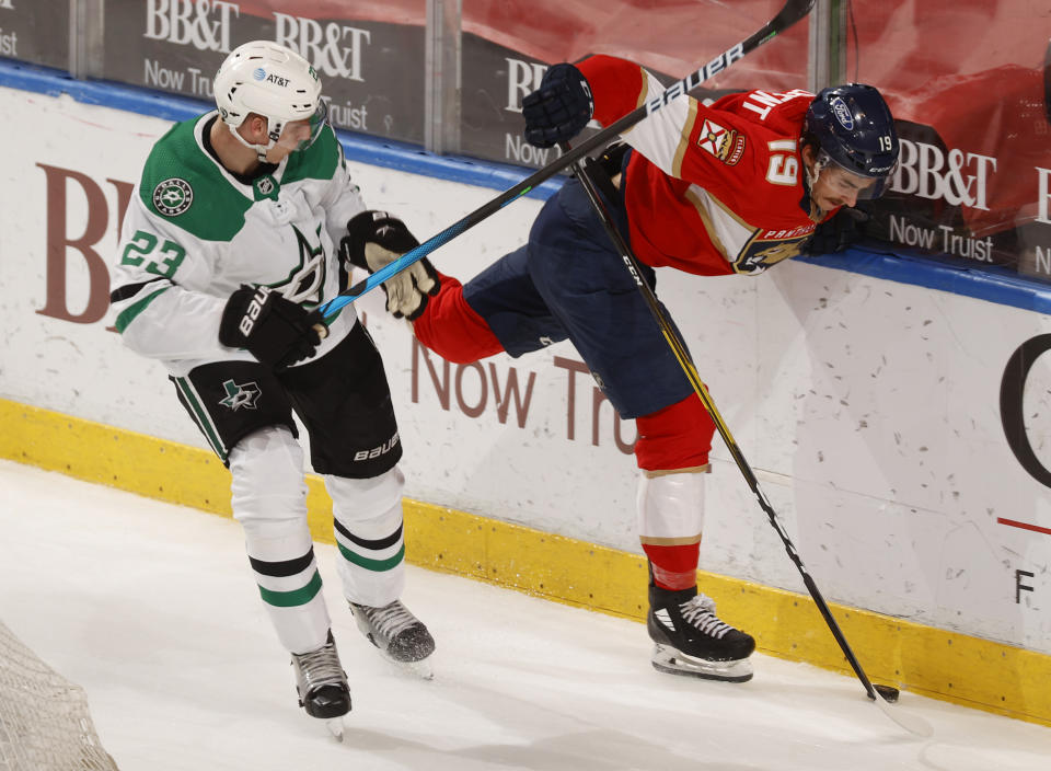 Dallas Stars defenseman Esa Lindell (23) checks Florida Panthers left wing Mason Marchment (19) off the puck during the second period of an NHL hockey game, Monday, May 3, 2021, in Sunrise, Fla. (AP Photo/Joel Auerbach)