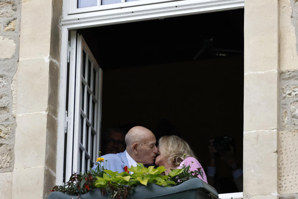 US WWII veteran Harold Terens, 100, left, and Jeanne Swerlin, 96, kiss from a window after celebrating their wedding at the town hall of Carentan-les-Marais, in Normandy, northwestern France, on Saturday, June 8, 2024. Together, the collective age of the bride and groom was nearly 200. But Terens and his sweetheart Jeanne Swerlin proved that love is eternal as they tied the knot Saturday inland of the D-Day beaches in Normandy, France. (AP Photo/Jeremias Gonzalez)