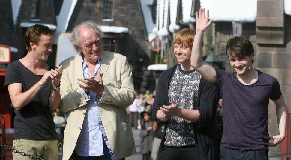 Daniel Radcliffe, right, cheers with the crowd, along with co-stars Tom Felton, from left, Michael Gambon and Rupert Grint