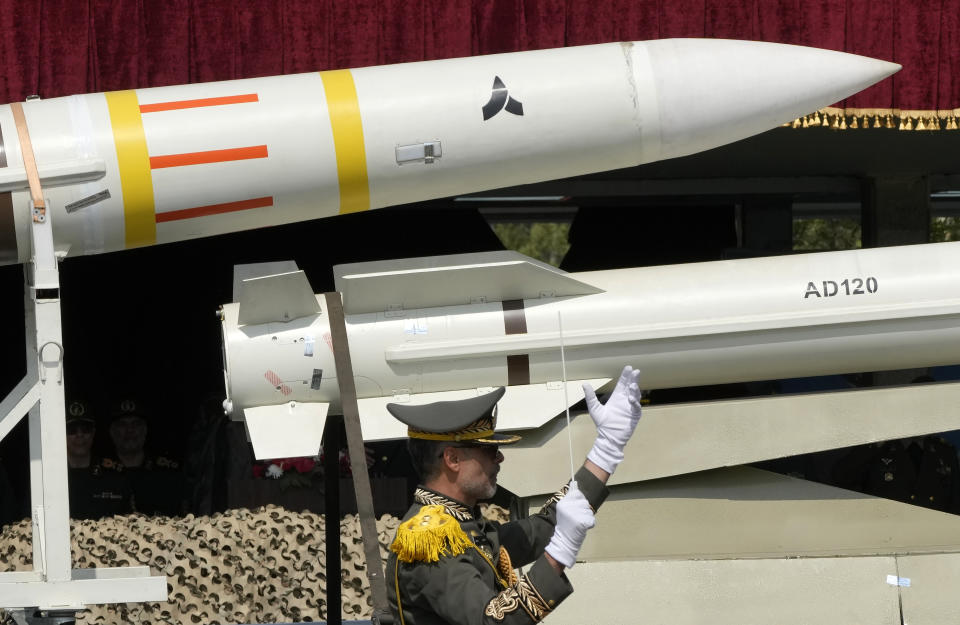 Missiles are carried on a truck as an Iranian army band leader conducts the music band during Army Day parade at a military base in northern Tehran, Iran, Wednesday, April 17, 2024. In the parade, President Ebrahim Raisi warned that the 