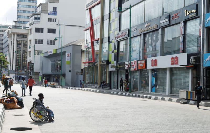 People walk past shops remain closed in Lagos