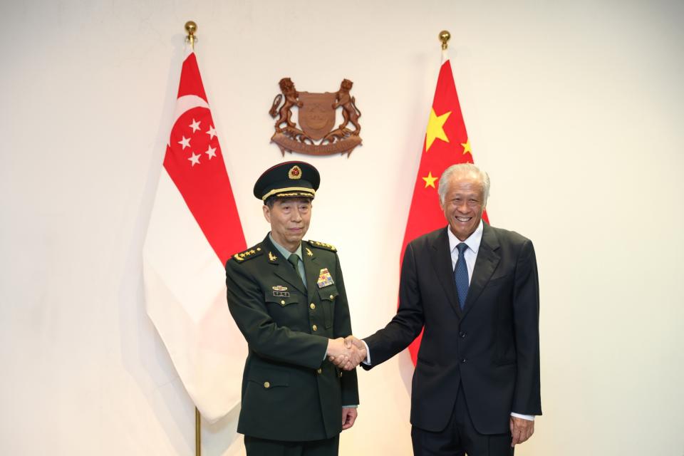 Li Shangfu, left, shakes hands with Ng Eng Hen in Singapore on June 1. Photographer: Lionel Ng/Bloomberg