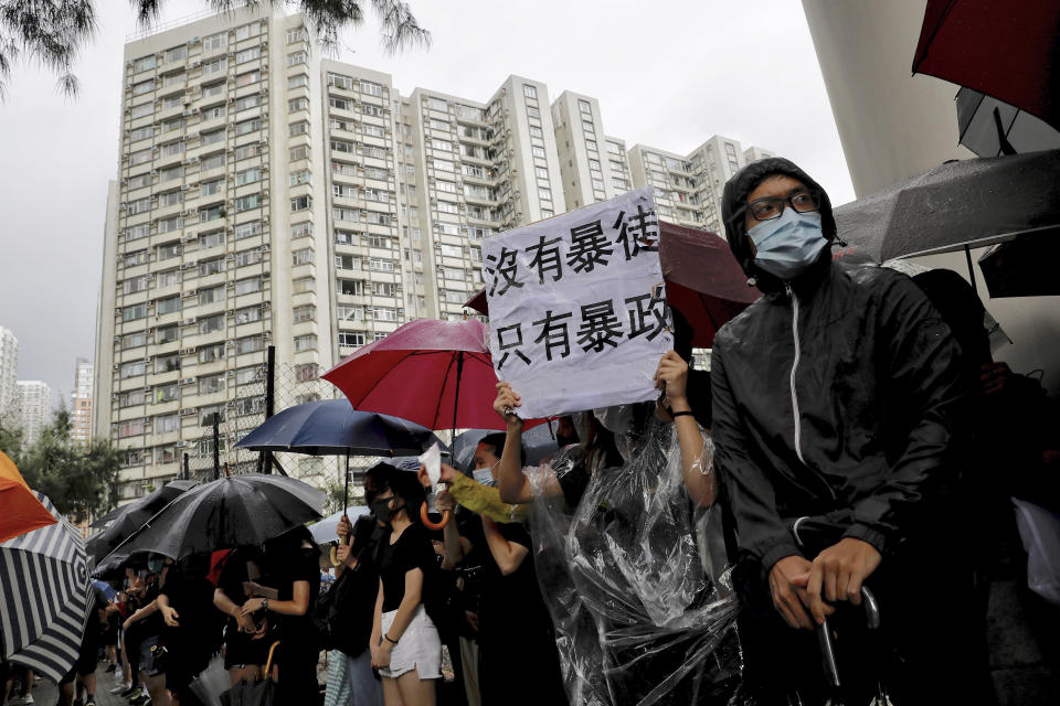 A protester holds a placard that reads: "No thug, only tyranny" while chanting slogans as they gather outside the Eastern Court in Hong Kong, Wednesday, July 31, 2019. Supporters rallied outside a court in Hong Kong on Wednesday ahead of a court appearance by more than 40 fellow protesters who have been charged with rioting. (AP Photo/Vincent Yu)