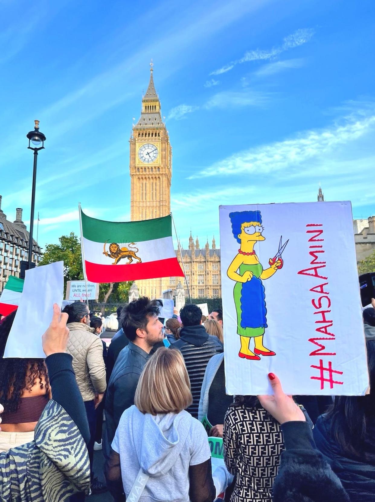 Un cartel con el dibujo de Marge Simpson cortándose el pelo en apoyo a las mujeres iraníes, obra de aleXsandro Palombo, en una manifestación en Londres. <a href="https://twitter.com/PalomboArtist/status/1581634741840666624?s=20&t=DH5V4hIgezRW7ELoZsco3A" rel="nofollow noopener" target="_blank" data-ylk="slk:aleXsandro Palombo / TW;elm:context_link;itc:0;sec:content-canvas" class="link ">aleXsandro Palombo / TW</a>