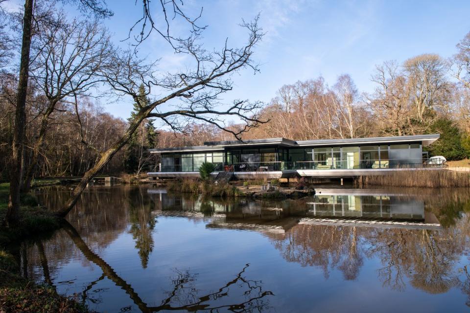 eco home sitting above the water surrounded by trees