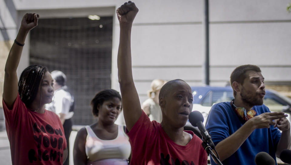 Demetria Hester, center, speaks to the media after being released from the Multnomah County Justice Center on Monday, Aug. 10, 2020, in Portland, Ore. Hester became a leading activist in the racial justice movement after she was assaulted by a white supremacist three years ago. Authorities said Hester won't be charged following her arrest early Monday. Hester had been booked on suspicion of disorderly conduct and interfering with a police officer during the protest that began Sunday night. Hester’s arrest drew a sharp rebuke from national Black Lives Matter activists, who are increasingly focusing on demonstrations in Oregon’s largest city. (Brooke Herbert/The Oregonian via AP)