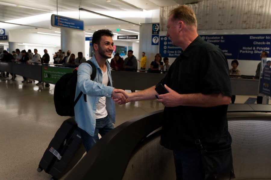 Michael White, a Navy veteran who was jailed in Iran for several years on spying charges, right, shakes hands with Michael’s former fellow prisoner and Iranian political activist Mahdi Vatankhah at the Los Angeles International Airport in Los Angeles, Thursday, June 1, 2023. Vatankhah, while in custody and after his release, helped White by providing White’s mother with crucial, firsthand accounts about her son’s status in prison and by passing along letters White had written while he was locked up. Once freed, White did not forget. He pushed successfully this year for Vatankhah’s admission to the United States, allowing the men to be reunited last spring, something neither could have envisioned when they first met in prison years earlier. (AP Photo/Jae C. Hong)
