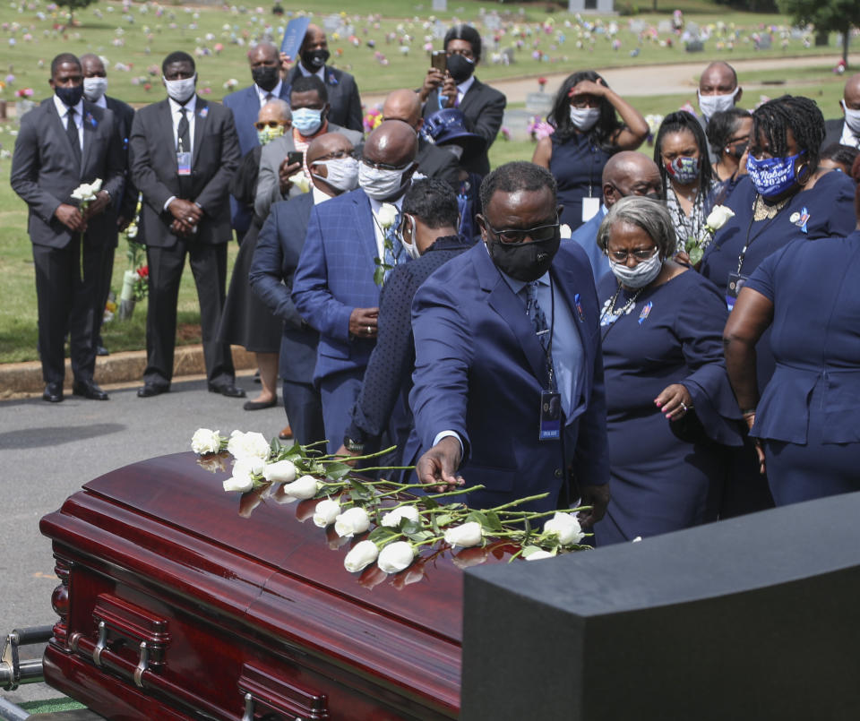 Familiares del representante John Lewis e invitados depositan flores sobre su féretro el jueves 30 de julio de 2020 en el Cementerio South View, en Atlanta. (Alyssa Pointer/Atlanta Journal-Constitution vía AP)