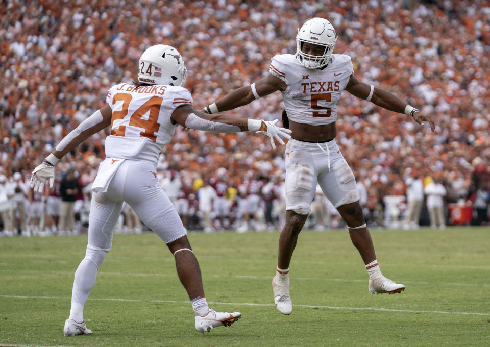 Texas running backs Bijan Robinson (5) and Jonathan Brooks (24) celebrates Brooks' touchdown run against Oklahoma during the second half of an NCAA college football game at the Cotton Bowl, Saturday, Oct. 8, 2022, in Dallas. Texas won 49-0. (AP Photo/Jeffrey McWhorter)