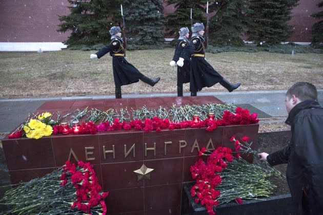 A man lays flowers in memory of victims killed by a bomb blast in a subway train in St. Petersburg at the memorial stone with the word Leningrad (St. Petersburg) at the Tomb of Unknown Soldier in front of the Kremlin wall in Moscow, Russia. Pavel Golovkin / AP