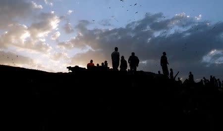 Rescue workers watch as excavators dig into a pile of garbage in search of missing people following a landslide when a mound of trash collapsed on an informal settlement at the Koshe garbage dump in Ethiopia's capital Addis Ababa, March 13, 2017. REUTERS/Tiksa Negeri