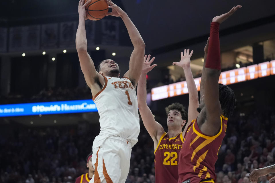 Texas forward Dylan Disu (1) drives to the basket against Iowa State forward Milan Momcilovic (22) and forward Tre King, right, during the second half of an NCAA college basketball game in Austin, Texas, Tuesday, Feb. 6, 2024. (AP Photo/Eric Gay)