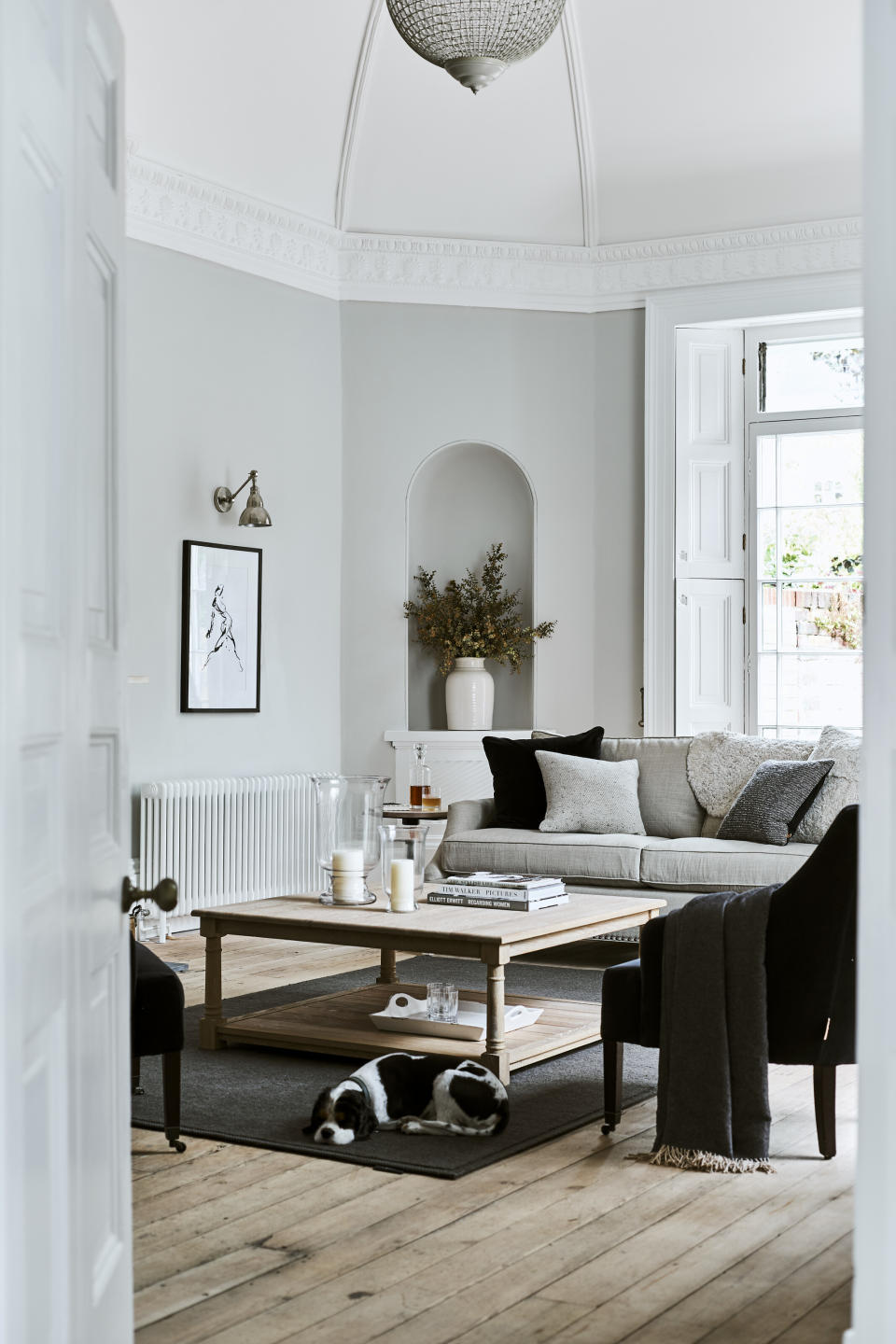 <p> Now, just because you have a good-sized coffee table doesn’t mean you should fill it to the brim with stuff. On the contrary – sometimes less is more. This beautiful display is the perfect example of this – a trio of books and two hurricane lamps like these from Wayfair - that’s all.  </p> <p> The hurricanes are clear glass, which allows you to see through them. This means they don't take up too much visual space and therefore maximize the airy feel in this light grey living room. </p>