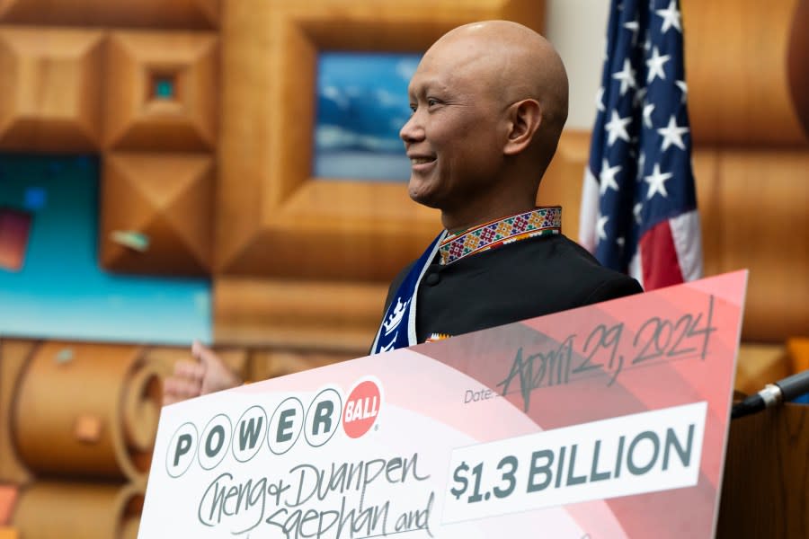 Cheng “Charlie” Saephan holds display check before speaking during a news conference where it was revealed that he was one of the winners of the $1.3 billion Powerball jackpot at the Oregon Lottery headquarters on Monday, April 29, 2024, in Salem, Ore. (AP Photo/Jenny Kane)