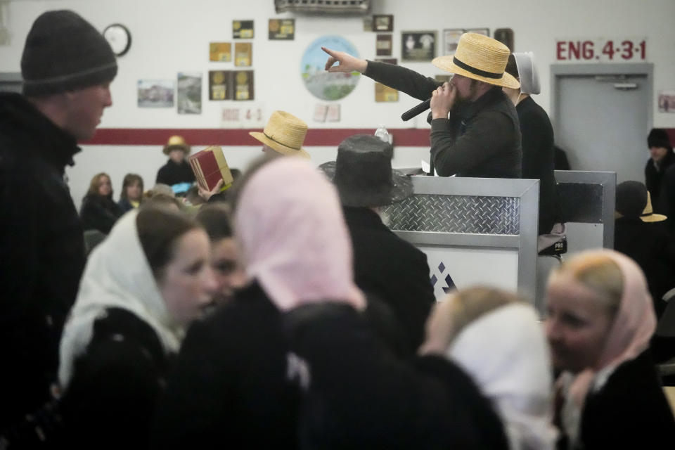 An auctioneer takes bids for books during the 56th annual mud sale to benefit the local fire department in Gordonville, Pa., Saturday, March 9, 2024. Mud sales are a relatively new tradition in the heart of Pennsylvania's Amish country, going back about 60 years and held in early spring as the ground begins to thaw but it's too early for much farm work. (AP Photo/Matt Rourke)