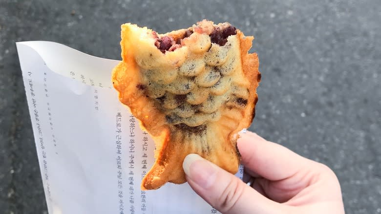 Hand holding a red bean-stuffed carp bread