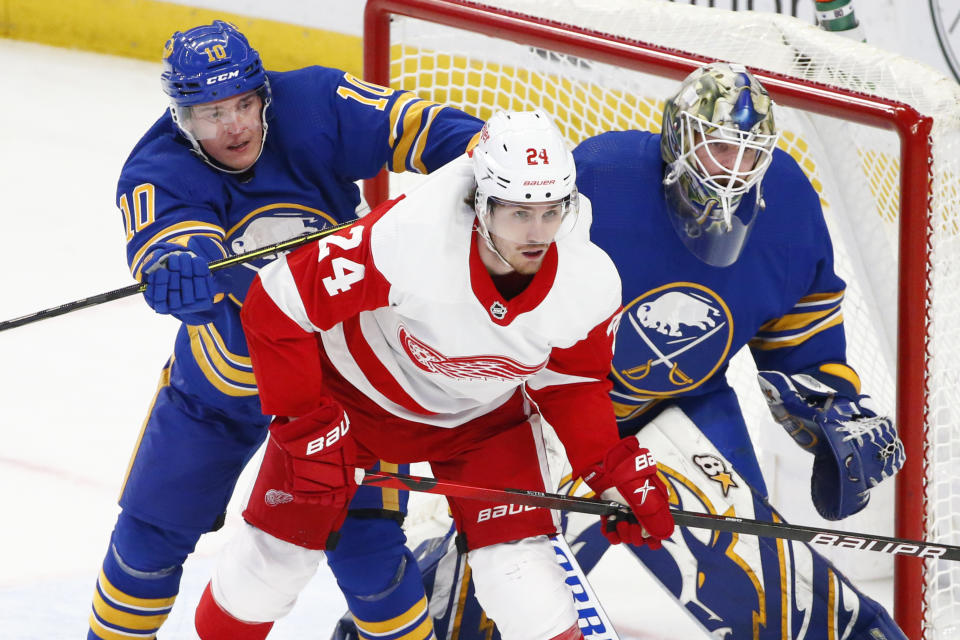 Buffalo Sabres defenseman Henri Jokiharju (10) and Detroit Red Wings center Pius Suter (24) battle for position in front of Buffalo Sabres goaltender Aaron Dell (80) during the second period of an NHL hockey game, Monday, Jan. 17, 2022, in Buffalo, N.Y. (AP Photo/Jeffrey T. Barnes)