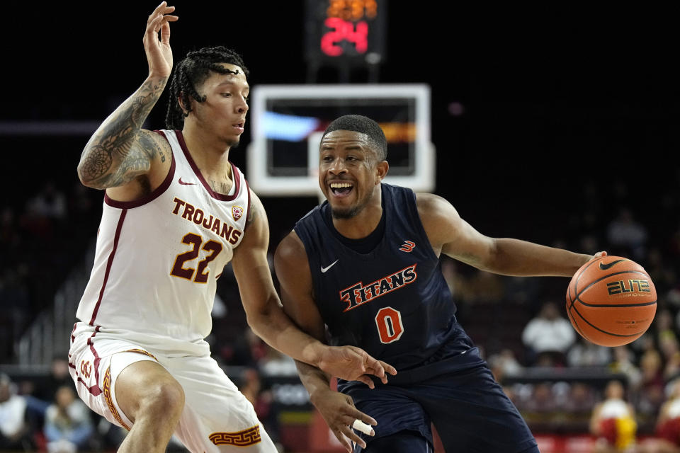 Cal State Fullerton guard Jalen Harris, right, drives by Southern California guard Tre White during the first half of an NCAA college basketball game Wednesday, Dec. 7, 2022, in Los Angeles. (AP Photo/Mark J. Terrill)