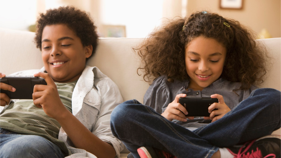 Siblings playing on their phones