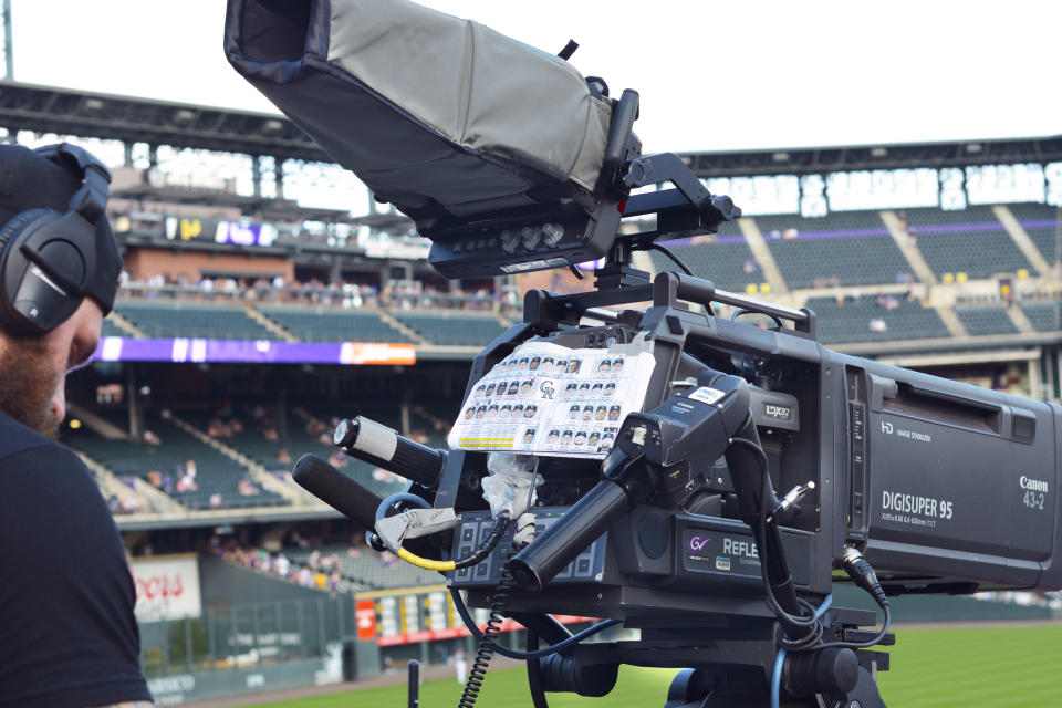 DENVER, COLORADO - AUGUST 31, 2019: A television cameraman prepares to operate a TV camera during a live broadcast of a Colorado Rockies Major League Baseball game at Coors Field in Denver, Colorado. (Photo by Robert Alexander/Getty Images)