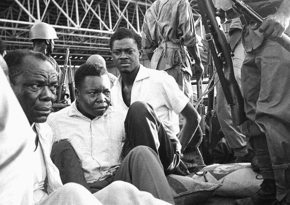 Congo's former prime minister Patrice Lumumba, center right, with hands tied behind his back, sits in a truck upon arrival at Leopoldville (now Kinshasa) Airport in Congo, Dec. 2, 1960, following his arrest the previous day. On Monday, more than sixty one years after his death, the mortal remains of Congo's first democratically elected prime minister Patrice Lumumba will be handed over to his children during an official ceremony in Belgium. (AP Photo, File)