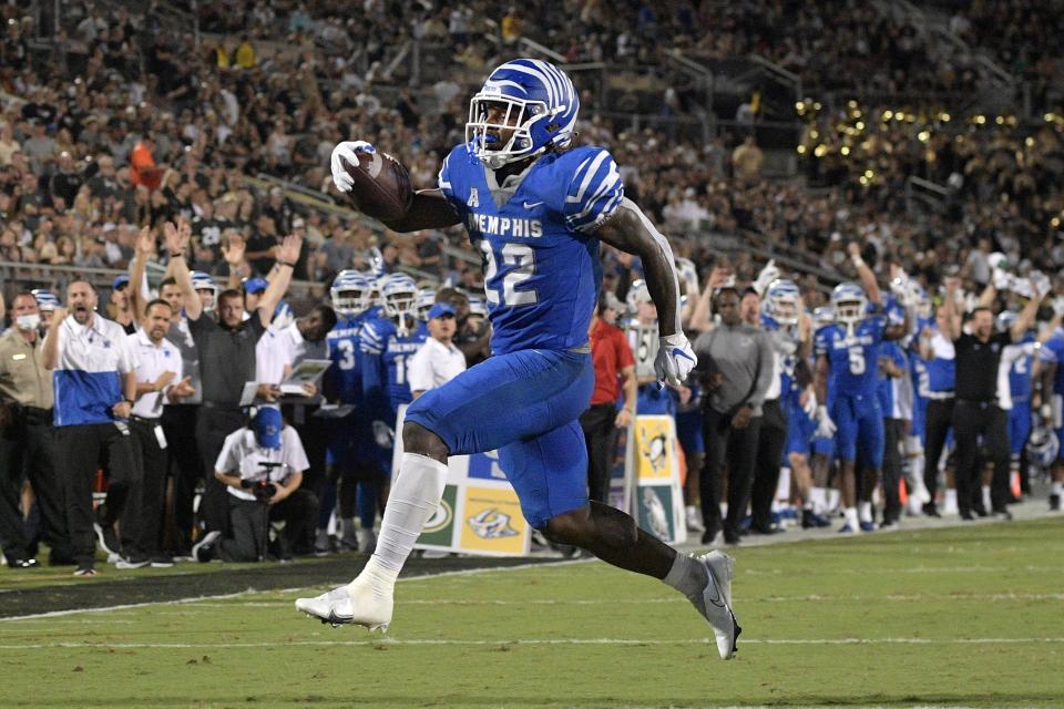 Memphis running back Brandon Thomas (22) rushes for a 9-yard touchdown against Central Florida during the first half of an NCAA college football game Friday, Oct. 22, 2021, in Orlando, Fla. (Phelan M. Ebenhack/Orlando Sentinel via AP)