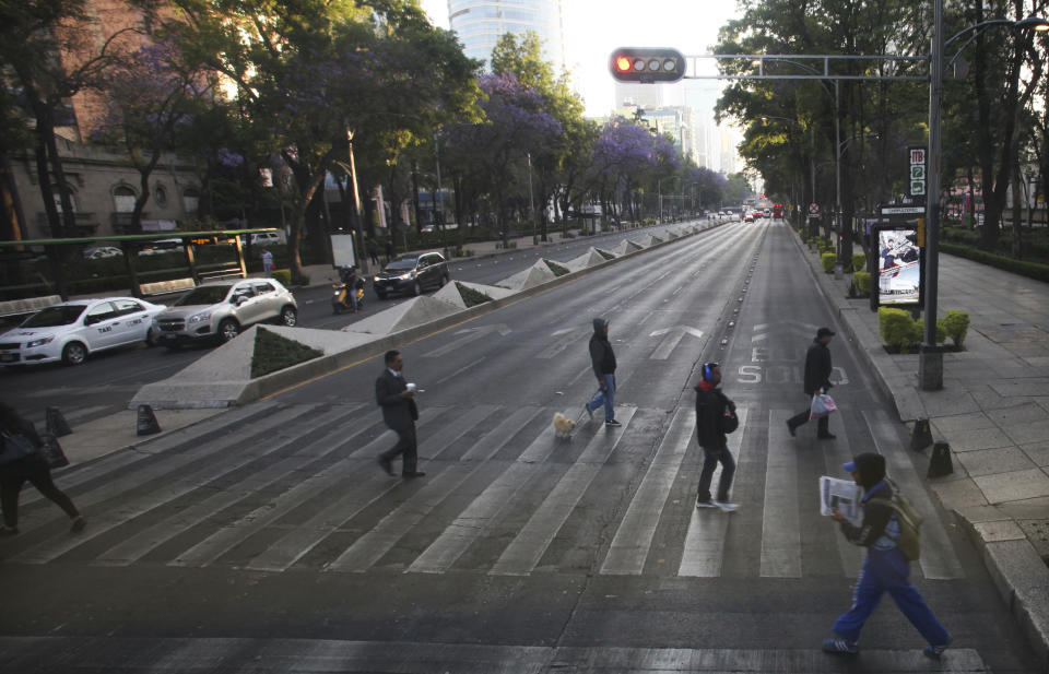 People walk across the Paseo de la Reforma during the national women's strike "A Day Without Women" in Mexico City, Monday, March 9, 2020. Thousands of women across Mexico went on strike after an unprecedented number of girls and women hit the streets to protest rampant gender violence on International Women's Day. (AP Photo/Marco Ugarte)