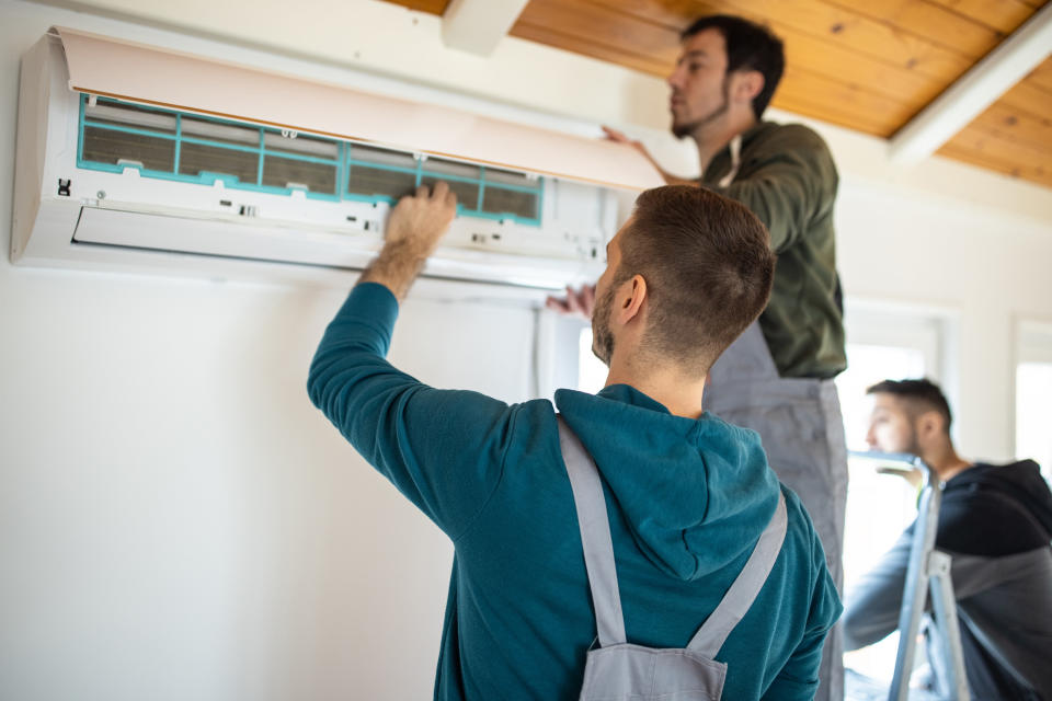 hvac repair people repairing a mini split system in a home