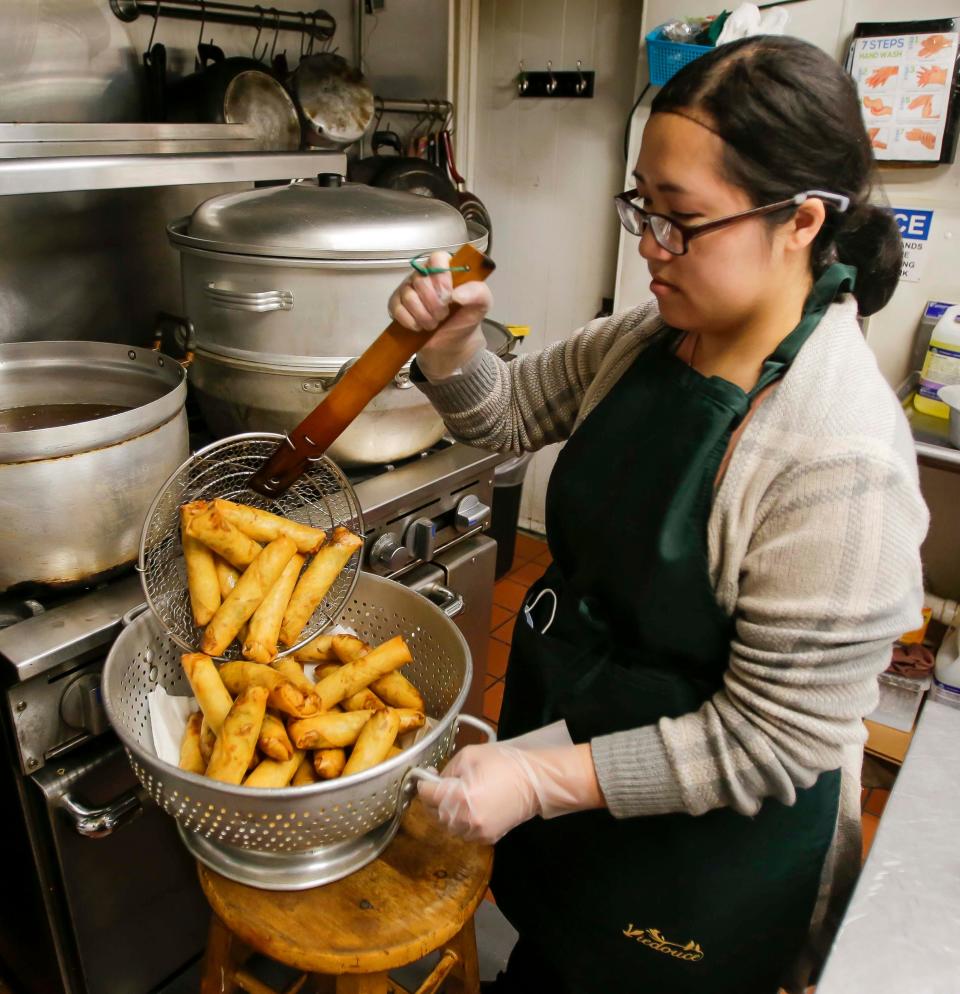 Union Asian Market’s Vanna Lor, of Sheboygan, pulls out Hmong egg rolls from the oil in Sheboygan. The market makes some 500 of the egg rolls daily.