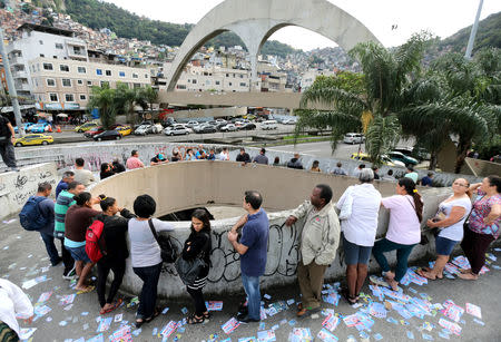 Brazilians stand in line outside a polling station to cast their votes in the presidential election, in Rio de Janeiro, Brazil October 7, 2018. REUTERS/Sergio Moraes