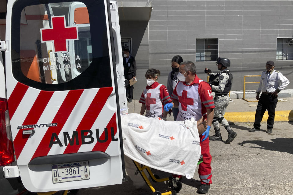 The Red Cross loads a patient, injured in a migrant detention center fire, into an ambulance, Tuesday, March 28, 2023, at a hospital in Cuidad Juarez, Mexico. According to Mexican President Andres Manuel Lopez Obrador, migrants fearing deportation set mattresses ablaze at the center, starting the fire that killed at least 40 migrants. (AP Photo/Morgan Lee)