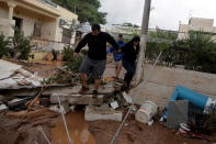 <p>Locals walk among debris in a yard, following a heavy rainfall in the town of Mandra, Greece, Nov. 15, 2017. (Photo: Alkis Konstantinidis/Reuters) </p>