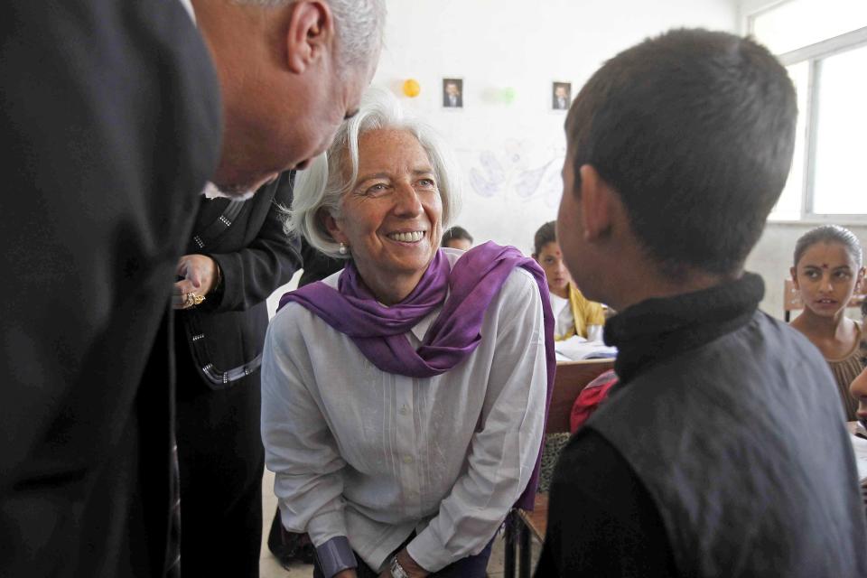 Christine Lagarde (C), International Monetary Fund Managing Director, speaks to a Syrian refugee student at Alimate school in Mafraq in this file photo from May 11, 2014. Lagarde has withdrawn as 2014 commencement speaker at Smith College�s in Northampton, Massachusetts after some faculty and students created an online petition accusing her of representing a corrupt system that fuels the oppression and abuse of women worldwide. REUTERS/Ali Jarekji/Files (JORDAN - Tags: POLITICS CIVIL UNREST SOCIETY IMMIGRATION BUSINESS EDUCATION)
