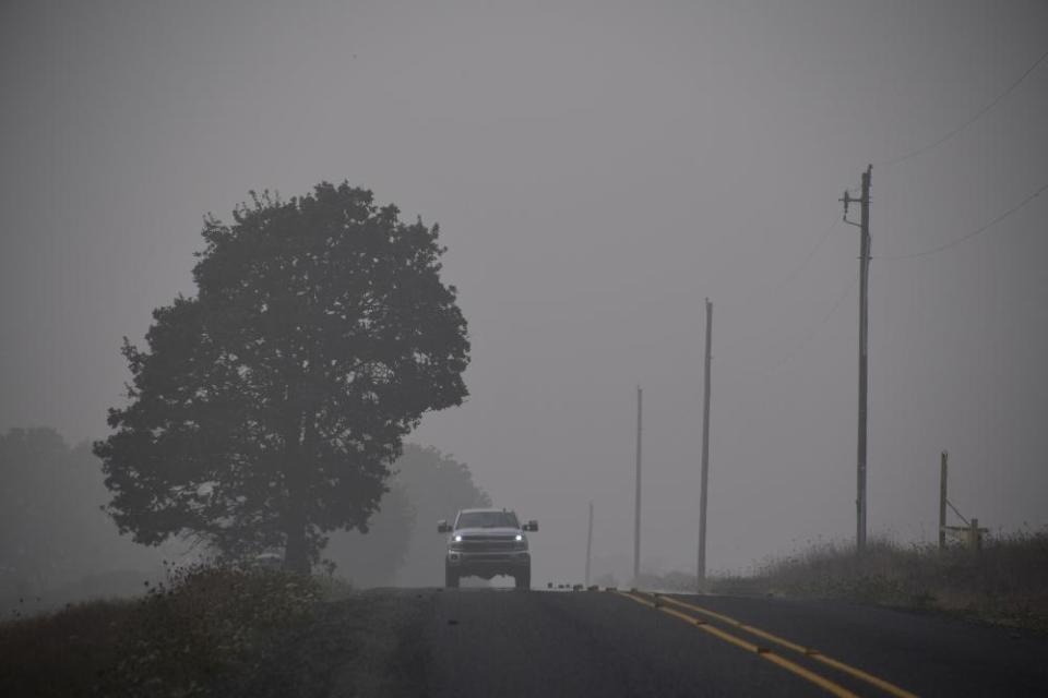 A truck drives on a road shrouded in smoke and fog in Sublimity, Oregon near the east edge of the Beachie Creek Fire, September 14, 2020.