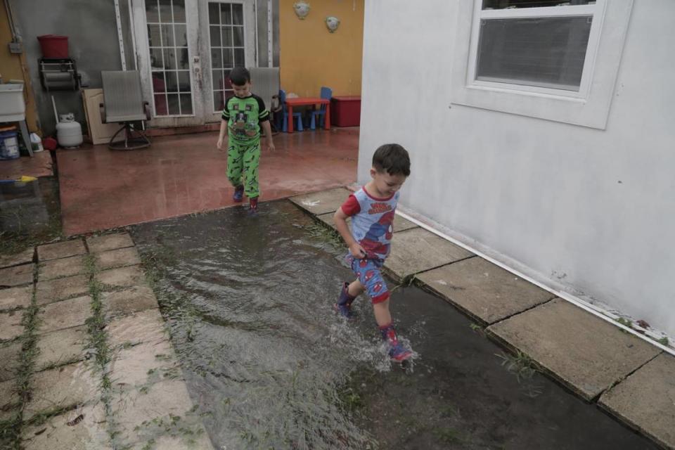 Daniel, 4, right, and his brother, Dariel, 6, play in floodwater in the backyard of their home in Miami Gardens on Nov. 9, 2020.