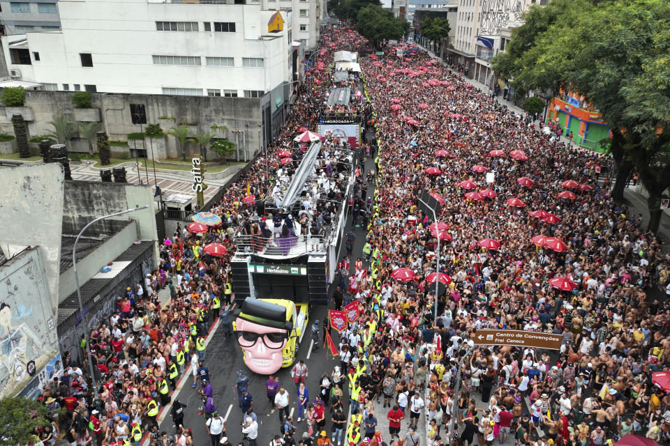 A behemoth sound truck popularly referred to as an electric trio makes it way through a street crowded with revelers during the "Academicos do Baixo Augusta" pre-Carnival street party in Sao Paulo, Brazil, Sunday, Feb. 4, 2024. In the seven decades since the first one hit Brazil’s streets, trios have grown ever more sophisticated and ever larger — with lights, LED screens, dressing rooms and VIP areas. (AP Photo/Andre Penner)