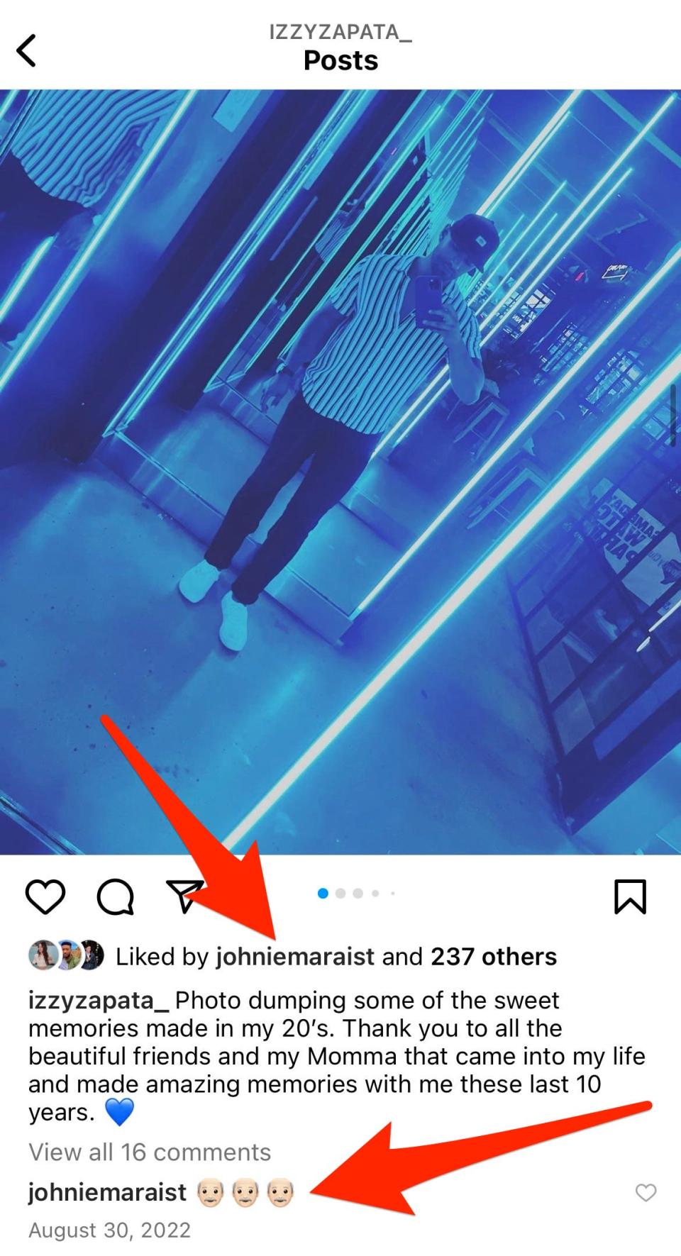 A screenshot of an Instagram mirror selfie from Izzy Zapata, posted in August 2022. Two red arrows point to a like and a comment (several grandpa emojis) from Johnie Maraist.