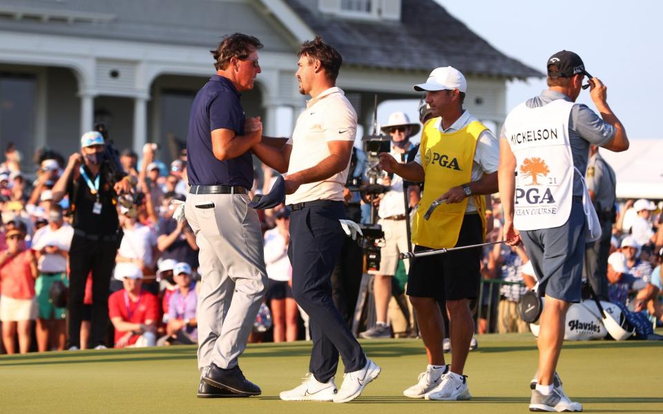 Phil Mickelson of the United States is congratulated by Brooks Koepka of the United States and caddie Ricky Elliott  - Getty Images