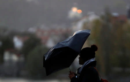 A woman holds an umbrella in heavy rain and strong wind in Prague, Czech Republic October 29, 2017. REUTERS/David W Cerny