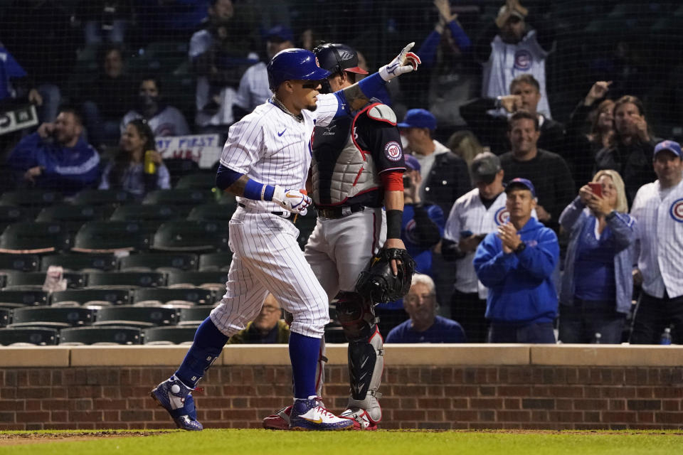 Chicago Cubs' Javier Baez (9) gestures as he crosses home plate after hitting a home run against the Washington Nationals during the sixth inning of a baseball game, Monday, May, 17, 2021, in Chicago. (AP Photo/David Banks)