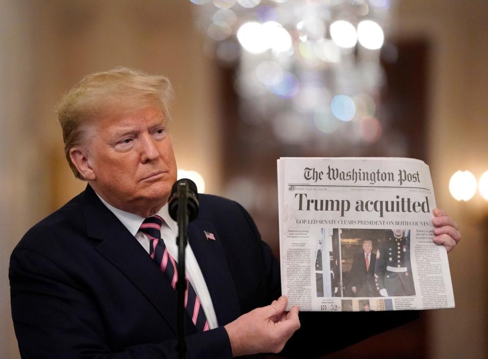 Trump holds a copy of The Washington Post a day after the US Senate acquitted him on two articles of impeachment in February 2020 (Getty Images)