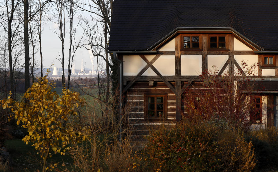 Smoke rises from chimneys of the Turow power plant located by the Turow lignite coal mine near the town of Bogatynia, Poland, Tuesday, Nov. 19, 2019. The Turow lignite coal mine in Poland has an impact on the environment and communities near the border of three neighboring countries, the Czech Republic, Germany and Poland. Plans to further expand the huge open pit mine have caused alarm among residents who fear things might get even worse. (AP Photo/Petr David Josek)