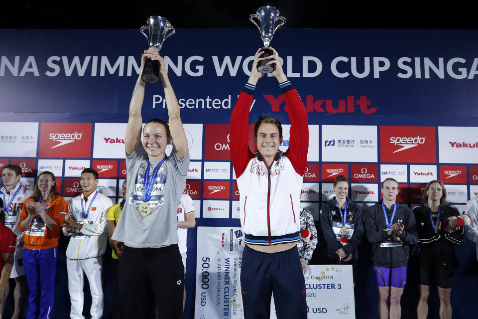 The two overall winners of the 2018 Fina Swimming World Cup series, Sarah Sjostrom (left) and Vladimir Morozov, hold aloft their trophies on 17 November, 2018. (PHOTO: Simone Castrovillari/Singapore Swimming Association)