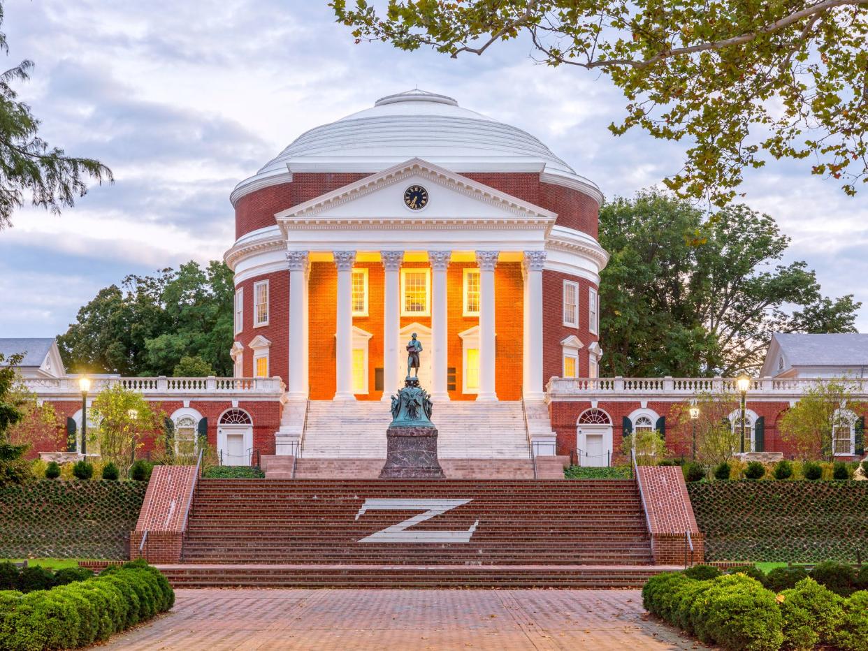 Charlottesville, USA - September 16, 2017: The Rotunda at the University of Virginia at dusk with Thomas Jefferson Statue in the foreground